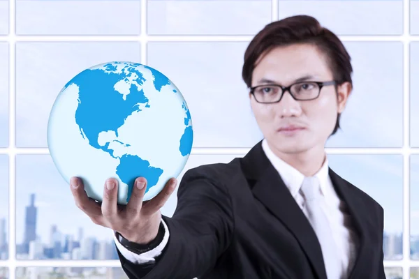 Businessman hold globe in hand - indoor — Stock Photo, Image