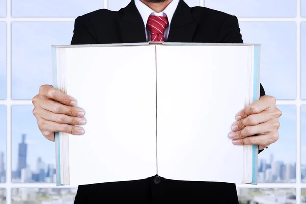 Businessman holding blank open book at office — Stock Photo, Image