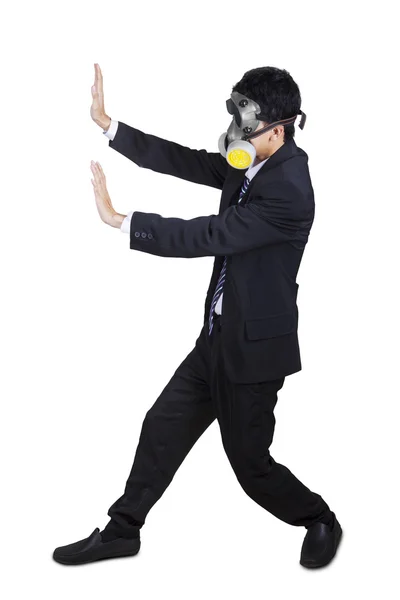 Businessman with a gas mask pushing something — Stock Photo, Image