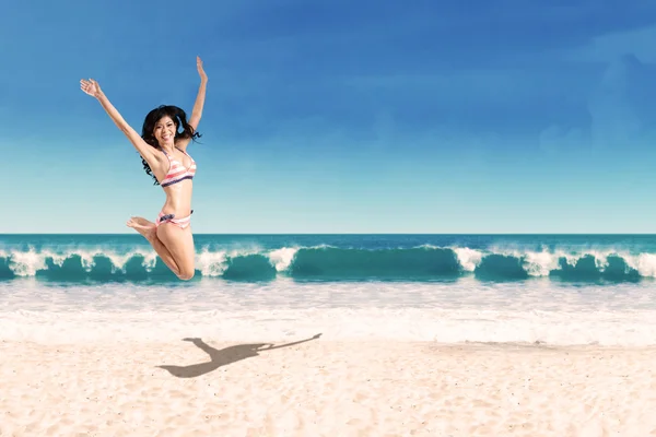 Donna eccitata in bikini che salta sulla spiaggia — Foto Stock