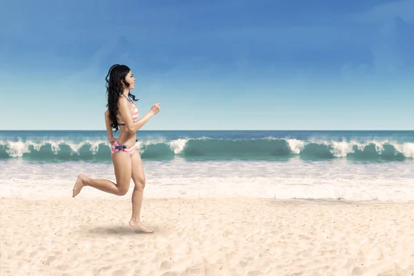 Mulher feliz correndo na praia — Fotografia de Stock