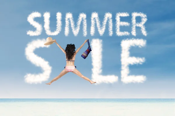 Summer sale clouds with excited woman jumping — Stock Photo, Image