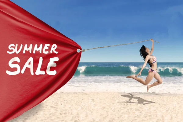 Woman pulling a banner of summer sale — Stock Photo, Image