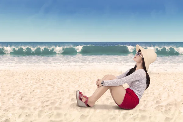 Femme assise sur la plage de sable blanc — Photo