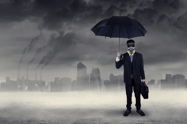 Businessman standing outdoors under air pollution — Stock Photo, Image