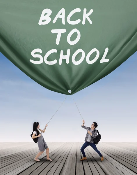 Högskolestudent dra en banner — Stockfoto