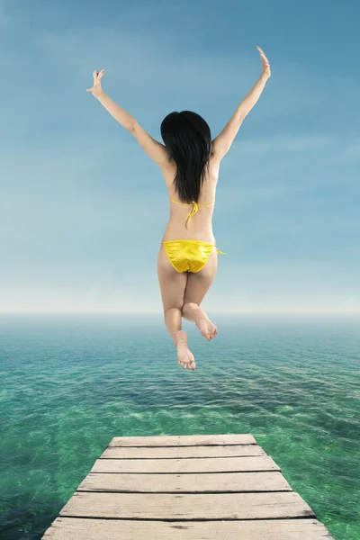 Glückliche Frau springt auf die Seebrücke — Stockfoto