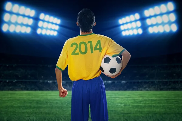 Jogador de futebol segurando bola no campo — Fotografia de Stock