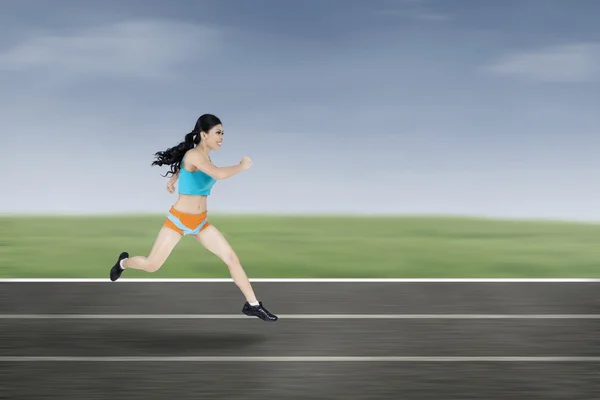 Mujer joven corriendo en el campo — Foto de Stock