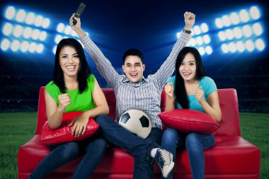 Ecstatic soccer fans watching tv