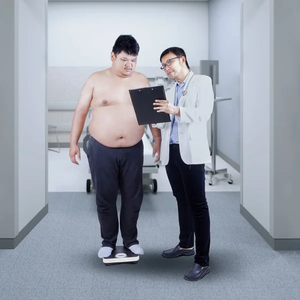 Врач показывает отчет толстому пациенту — стоковое фото