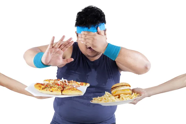 Hombre gordo rechazando comida chatarra — Foto de Stock