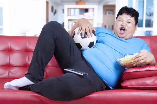 脂肪の男を見てサッカーの試合自宅で — ストック写真