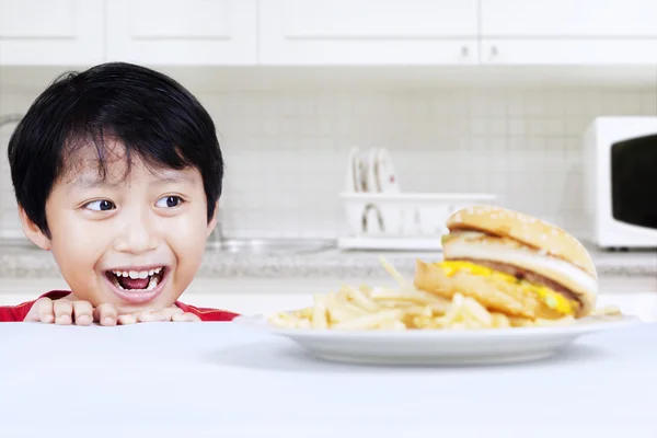 Hungriger Junge schaut sich Rindfleisch-Burger an — Stockfoto