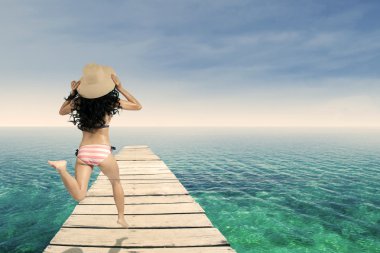 iskelede çalışan çizgili bikini giyen kadın