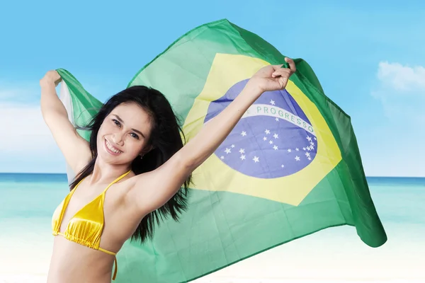 Mulher sexy segurando bandeira brasileira à beira-mar — Fotografia de Stock