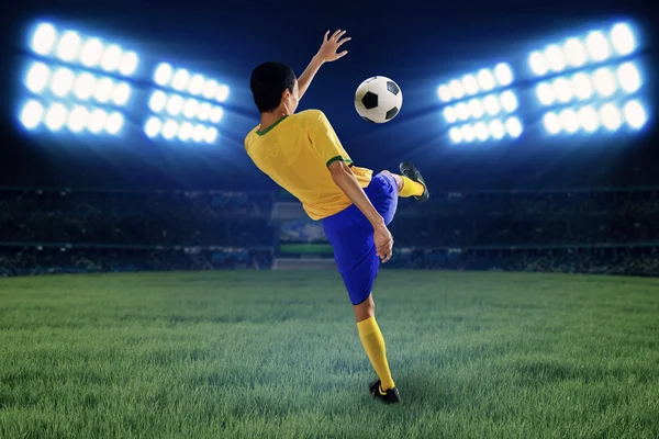 Soccer player kicking the ball at field — Stock Photo, Image