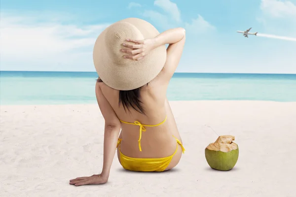 Woman wearing swimsuit sitting on beach — Stock Photo, Image