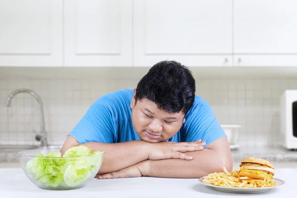 Hombre obeso mirando ensalada — Foto de Stock