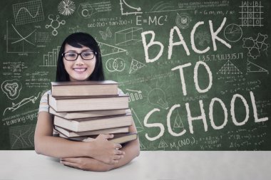 mutlu öğrenci ders kitaplarında sınıfta tutar.