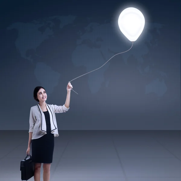 Affärskvinna innehar lampa ballong — Stockfoto
