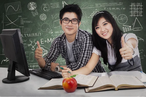 Cheerful students showing tumbs-up — Stock Photo, Image