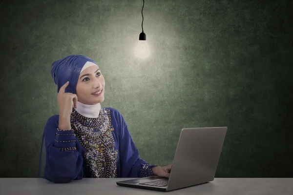 ノート パソコンと魅力的な女性イスラム教徒考えを持っています。 — ストック写真