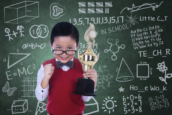 Bonito nerd segurando troféu na classe — Fotografia de Stock