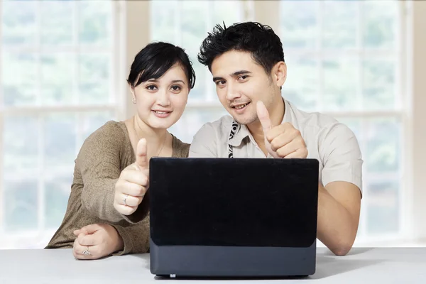 Casal feliz e laptop mostrando polegares para cima — Fotografia de Stock