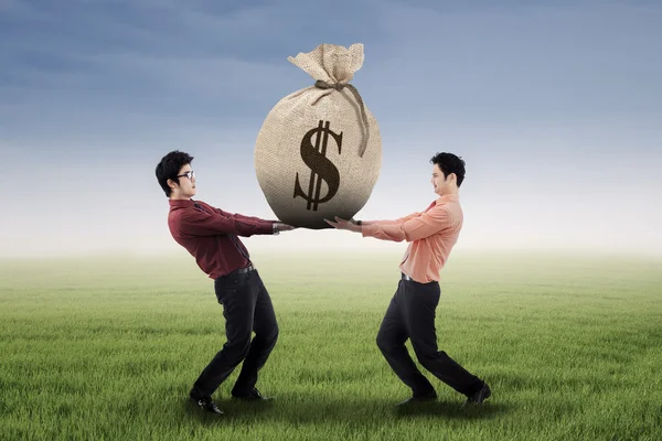 Two businessmen carrying a money bag — Stock Photo, Image