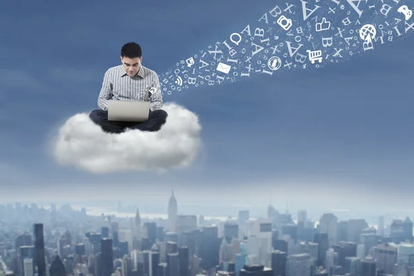 Man using laptop over cloud — Stock Photo, Image