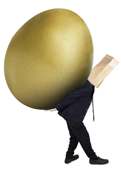 Anonymous businessman is carrying golden egg — Stock Photo, Image
