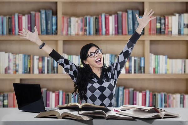 Fröhliche Studentin studiert in Bibliothek — Stockfoto