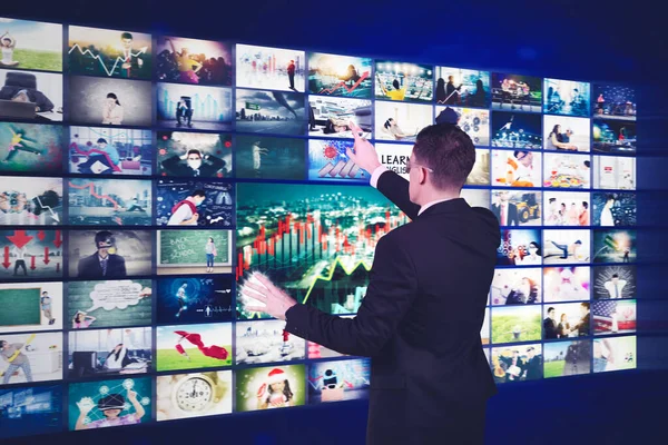 Erkek yönetici metaevrende sosyal ağ hizmeti verirken sanal ekrandaki resimlere dokunuyor