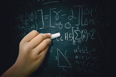 Ders çalışırken tahtaya matematik formülü yazan kız öğrencinin el yazısını kapat.