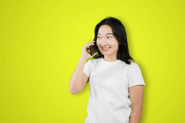 Счастливая Молодая Женщина Делает Телефонный Звонок Стоя Студии Зеленым Фоном — стоковое фото