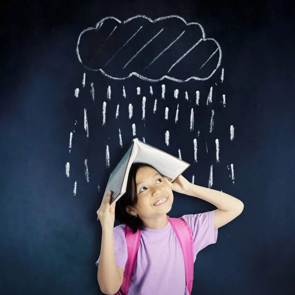 Öğrenci Kız Sınıfta Yağmur Yağmasını Önlerken Kafasına Açık Bir Kitap — Stok fotoğraf