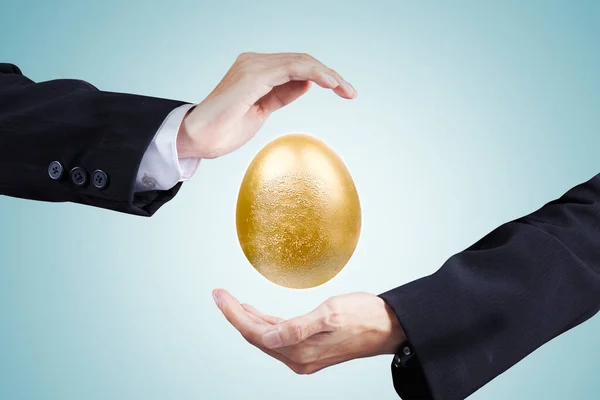 Επιχειρηματίας Χέρια Προστασία Ένα Χρυσό Αυγό Ενώ Στέκεται Στο Στούντιο — Φωτογραφία Αρχείου