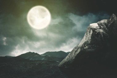 Dolunay arkaplanlı güzel bir dağ manzarası. Gece yarısı vuruldu.