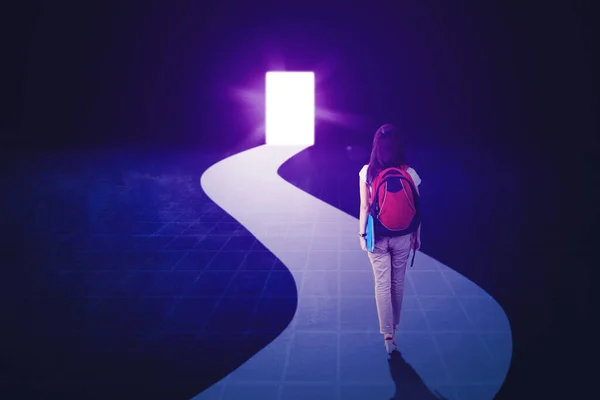 明るいドアに向かって歩いている間 バックパックを持っている女性学生の背面図 — ストック写真