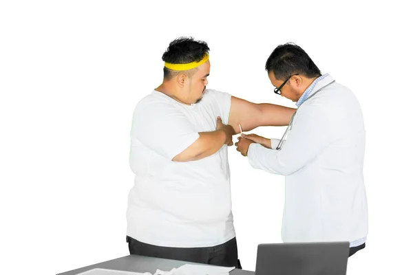 スタジオに立っている間 男性医師は 彼の患者の脂肪上腕をチェックするためにキャリパーを使用しています 白地に隔離された — ストック写真
