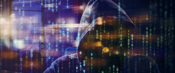 Double exposure of hooded hacker with binary code and blurred sparkling light background