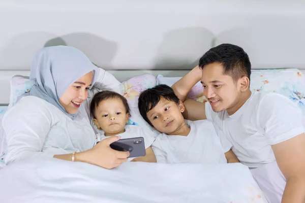 Top View Muslim Family Watching Video Smartphone While Lying Bedroom — Stock Photo, Image