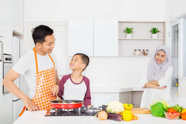 Müslüman Kadın Mutfakta Dikilirken Yemek Pişiren Kocasına Oğluna Bakıyor Evde — Stok fotoğraf