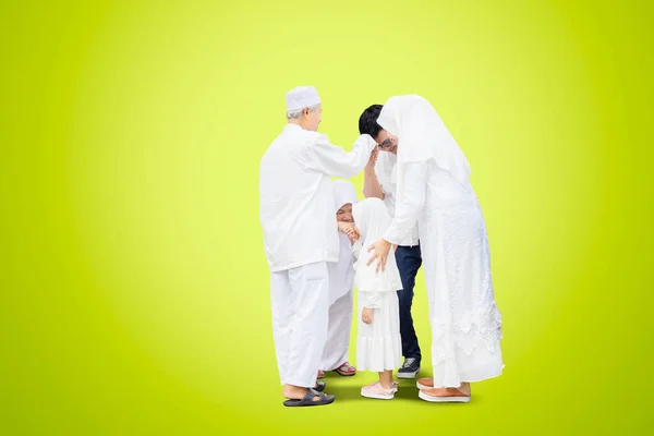 三代穆斯林家庭在有绿屏背景的工作室见面时握手 — 图库照片