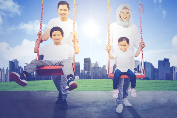 Muslimska Föräldrar Med Sina Barn Leker Med Gungor Samtidigt Kul — Stockfoto