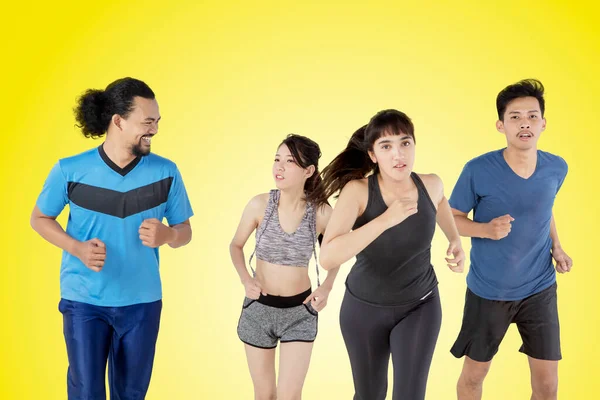 Group Diversity People Wearing Sportswear While Jogging Together Studio Yellow — Stock Photo, Image