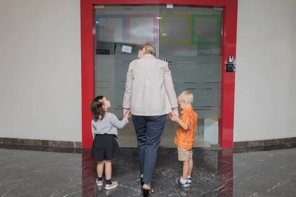 Rear View Young Mother Holding Hands Her Children While Accompanying — Foto de Stock