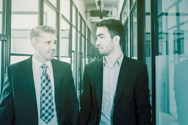 Πορτρέτο Δύο Επιχειρηματιών Συνομιλούν Ενώ Περπατούν Στο Διάδρομο Του Γραφείου — Φωτογραφία Αρχείου