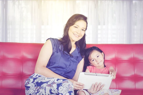 Young Woman Her Daughter Using Table While Sitting Together Sofa — Foto Stock